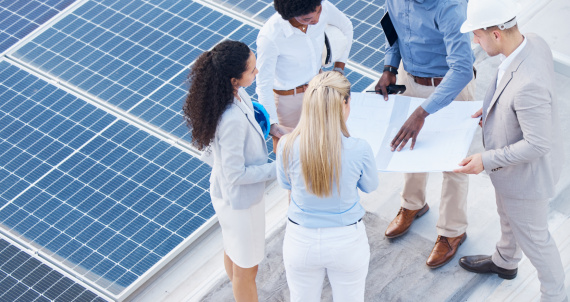 Solar energy, business people or engineering team with blueprint on roof building grid technology f.